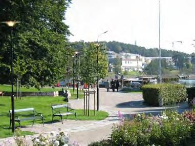 Längs gångstråket ligger en bred blomsterrabatt med perenner och klematis i färgteman.