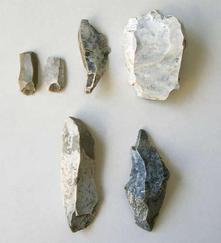 Fig. 8. Några av flintfynden. Övre raden visar fynd från matjordslagret: Två spånfragment, ett avslag med retusch och en svallad skrapa.