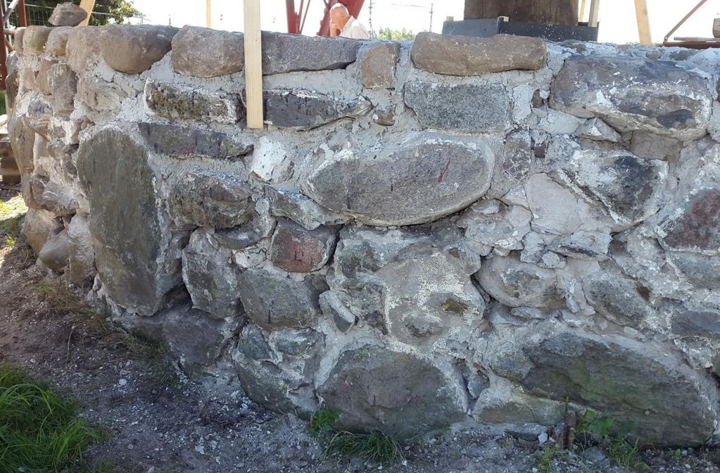 Stensockelns norra sida, efter att delar av den yttre muren tagits ner och lagts om i kalkbruk. rade med och alla smidda spikar återanvändes.