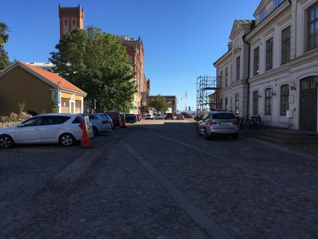 Kvällstid är stadsrummet belyst av gatubelysning.