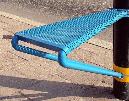 Bänkens konstruktion består nu främst av två vinklade bockar i stålrör, med sittytan i perforerad plåt draperad över dessa. Anslutningen mot t.
