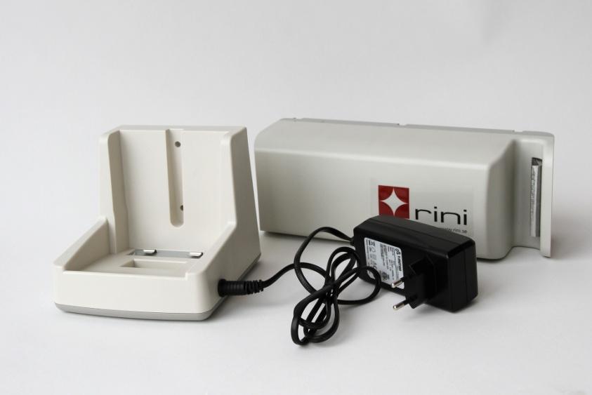 För att ladda batteriet lossa det först från operationsbordet och placera det i den externa laddaren. Under laddning lyser en gul LED som ändras till grön när batteriet är färdigladdat.