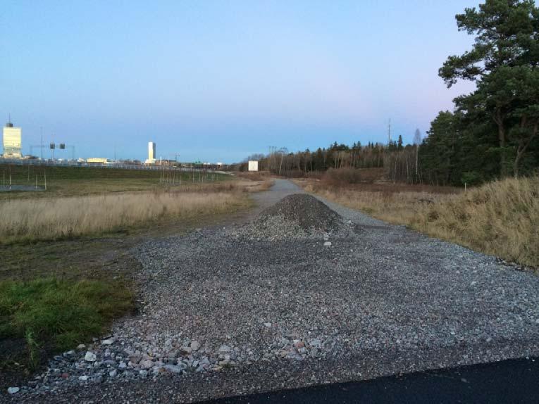 På vägen ligger flera högar med jordmassor.