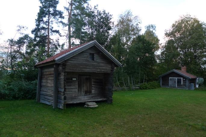 Objekt 42 Timmerbyggnad med bilade stockar och tegeltak som står på en hembygdsgård (foto ovan t.h.).