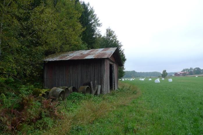 Objekt 60 Tidigare rödfärgsmålad brädlada med plåttak som står i kanten mellan vallåker och skog (foto nedan t.