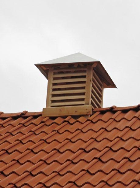 Nytillverkad ventilationshuv längst åt öster. Här är en av de nytillverkade ventilationshuvarna monterad på taket. Notera brädbiten som monterats mot tegeltaket för att leda bort nederbörd.