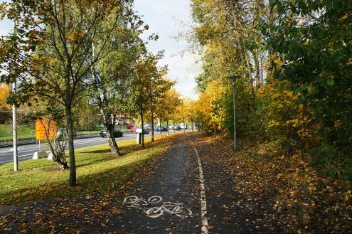 Överst: Ursviksvägen idag med gång- och cykelväg.under: illustration av Ursviksvägen med ny utformning och ny bebyggelse. Karaktären längs Ursviksvägen förändras genom förslaget.