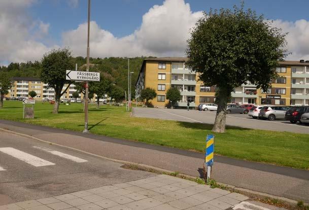 framför bebyggelsen finns större asfalterade parkeringsytor.