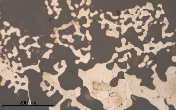 Järnprov från R432 stick 2, prov 2. Detalj på det svampiga järnet som består av ferrit (Svagt bruna fält), dvs. det är kolfritt. Foto från mikroskopet på etsat prov.
