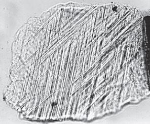 smala, tunna stråk av amorft glas orienterade parallellt med rationella kristallografiska plan i kristallen (se Fig 4).