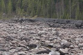 Den torrlagda Hotingsån, nedanför regleringsdammen i Lillflyn, vittnar om att det flottades i ån.
