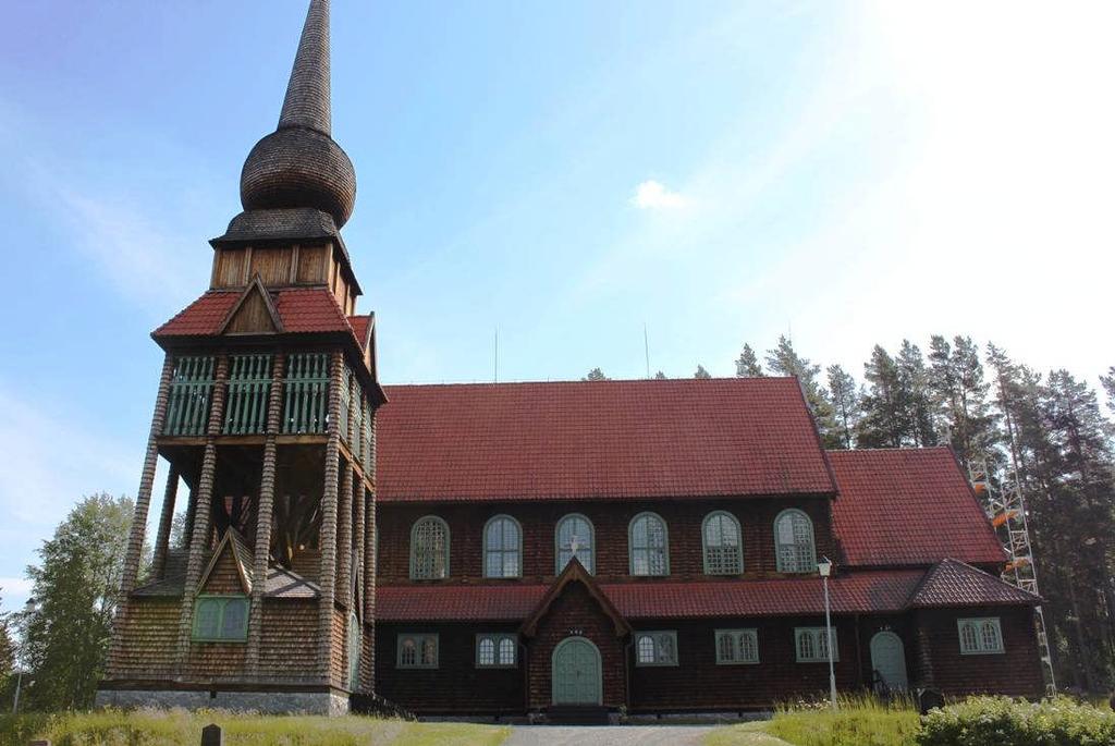 Kyrkan och klockstapeln innan restaureringen. Fotografiet är taget från uppfartsvägen till kyrkan och visar den västra sidorna som är mycket blekta. Ställningar resta framför den södra gaveln.