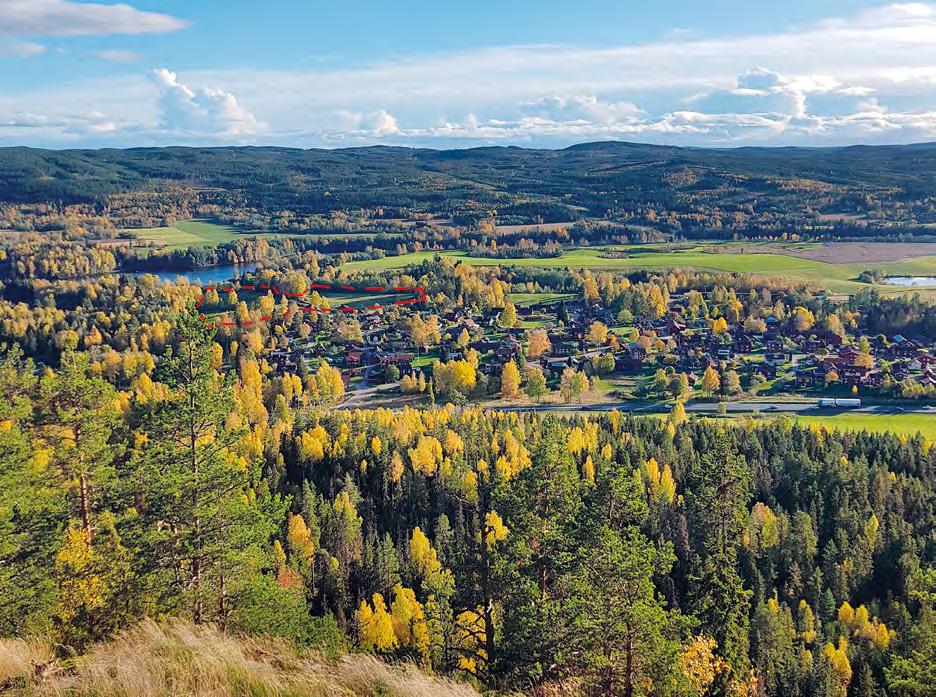 Illustration 3. Fotografi över Djurmo by och utredningsområdet, markerat med röd streckad linje. Fotografiet är taget från Djurmo klack, mot syd.