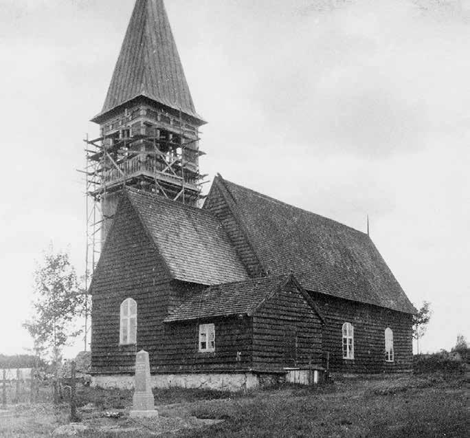 Fig. 115. Aneboda medeltida träkyrka, omtalad som nyuppförd 1346. Fotot är taget 1899 strax före rivningen. I bakgrunden syns den nya kyrkans torn under uppförande.