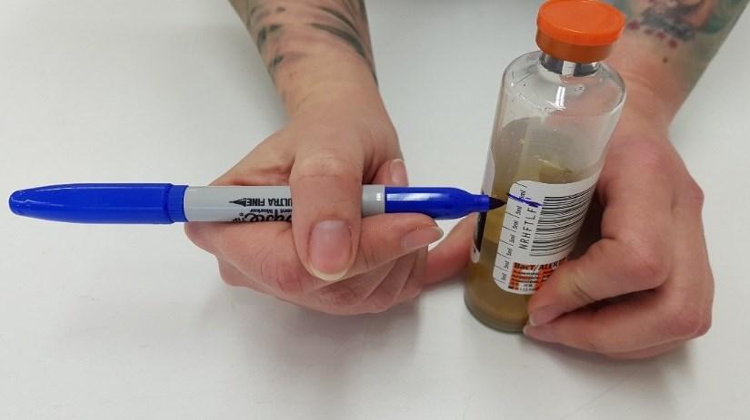 Ställ flaskan på bordet och markera med penna önskad volym blod som ska dras från patienten.