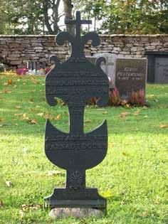 En klassicistisk vård i svart granit över f d nämndeman Karl Petersson och hans familj (KI Långlöt kyrkog 048) Tidig 1900-tals vård med en öppen bok på krönet (KI