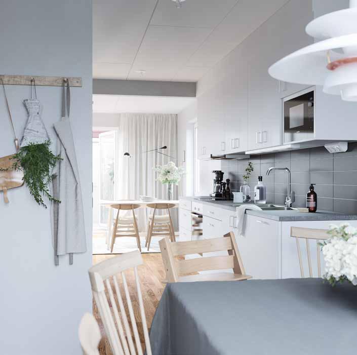 VITVAROR VÅRT VAL Bilden visar ett sobert kök med en vit kökslucka, bänkskiva Terazzo (laminat) stänkskydd Horisont grå blank samt vita vitvaror och integrerad diskmaskin.