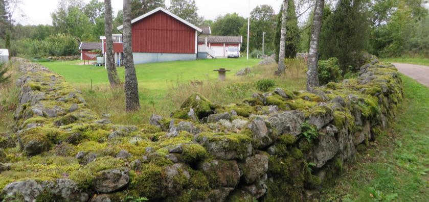Platsen ligger på andra sidan nya vägen, norr om gamla bykärnan, längs med