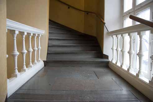 TRAPPHUSET TILL FJÄLLGATAN 23B MED KALKSTEN OCH RÄCKEN AV SVARVADE BALUSTERDOCKOR FRÅN BYGGNADSTIDEN. FOTO J. MALMBERG. våningar högt och innehöll lärarbostäder och internatsrum för eleverna.