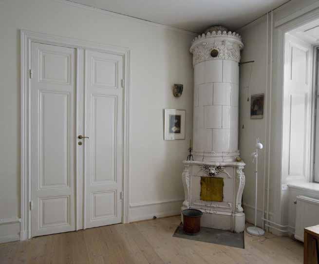 BEVARAD INREDNING FRÅN 1800-TALETS ANDRA HALVA MED PARDÖRRAR, KAKELUGN, SOCKEL- OCH FÖNSTERPANEL. FOTO J. MALMBERG.