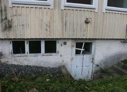 Balkongen sträcker sig ut med det förhöjda fasadpartiet som har balkongdörrar och fönster med låg bröstning.