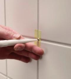 Skär fogarna fria och sedan ett spår längs plattkanterna runt 2 cm innanför fogen.