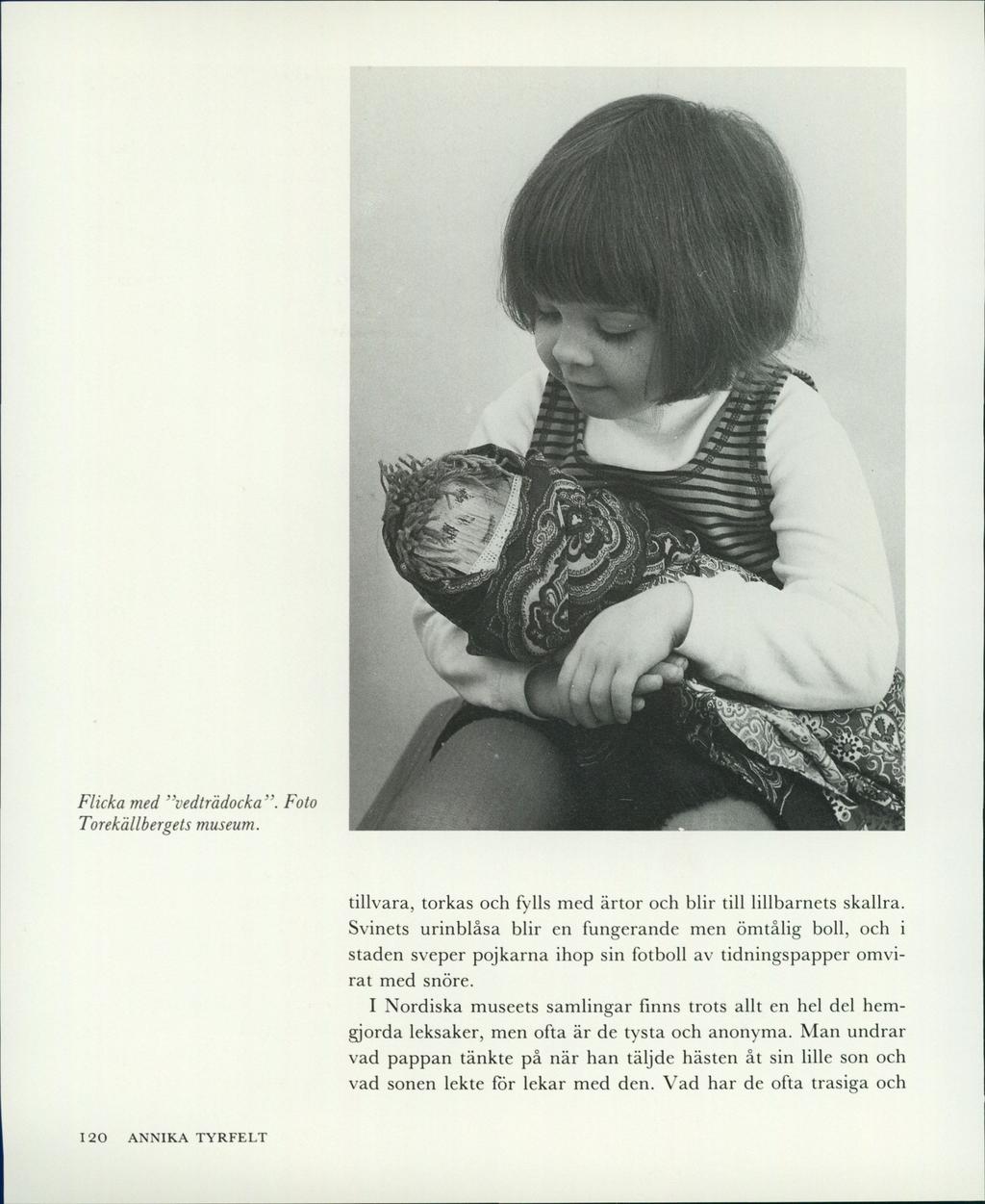 Flicka med vedträdocka. Foto Torekällbergets museum. tillvara, torkas och fylls med ärtor och blir till lillbarnets skallra.