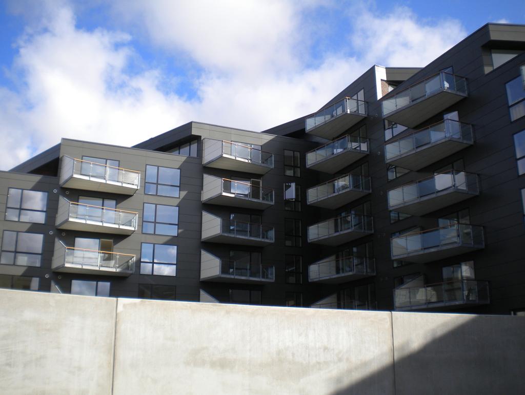 Lägenheter Fasad med fibercementskiva Fasaderna har ett modernt uttryck med rymliga fönster som hålls ihop arkitektoniskt av horisontella linjer som markerar skillnaderna mellan våningarna.