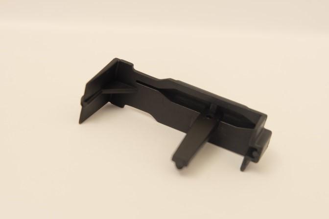 Figure 7a-b. The magazine follower from two different angles. Glass fiber reinforced polyamide 6.6 (PA6.6-30% gf) is a composite that contains 30 % of reinforced glass-fiber.