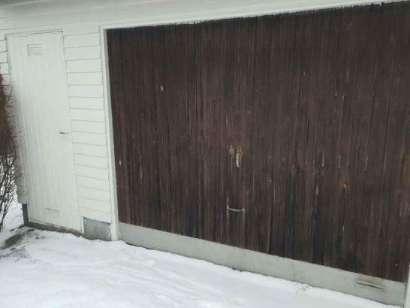 Garage Utvändigt Dörr på långsida har mindre rötskador.