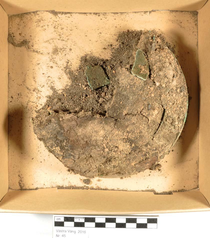 Arbetet startar med att avlägsna de lösa klumparna samt avlägsna materialet kring ringen. Vid undersökningen upptäcks flera lösa mindre cu fragment, spritt liggande samt två något större.