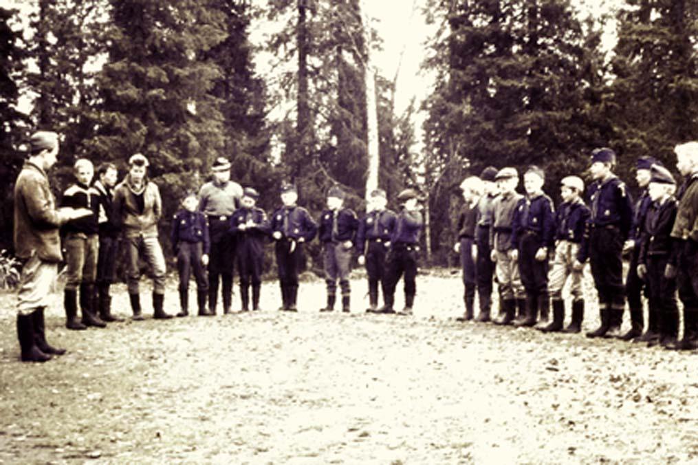 Scoutkåren i Korpilombolo vid en samling år 1960. Bengt Dahlin längst till vänster leder mötet. Verksamheten bedrevs mest utomhus då vi inte hade några lokaler.