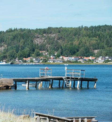 Husens placering bildar ett välkomnande kvarter, där fasadernas jordnära färgsättning harmoniserar fint med den intilliggande naturen med skog och berghällar.