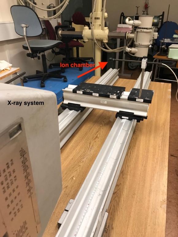 Figure 3.10: Measurement arrangement of the kerma measurements free in air. The arrow shows the ion chamber and the x-ray system is shown in the bottom left corner in the figure.