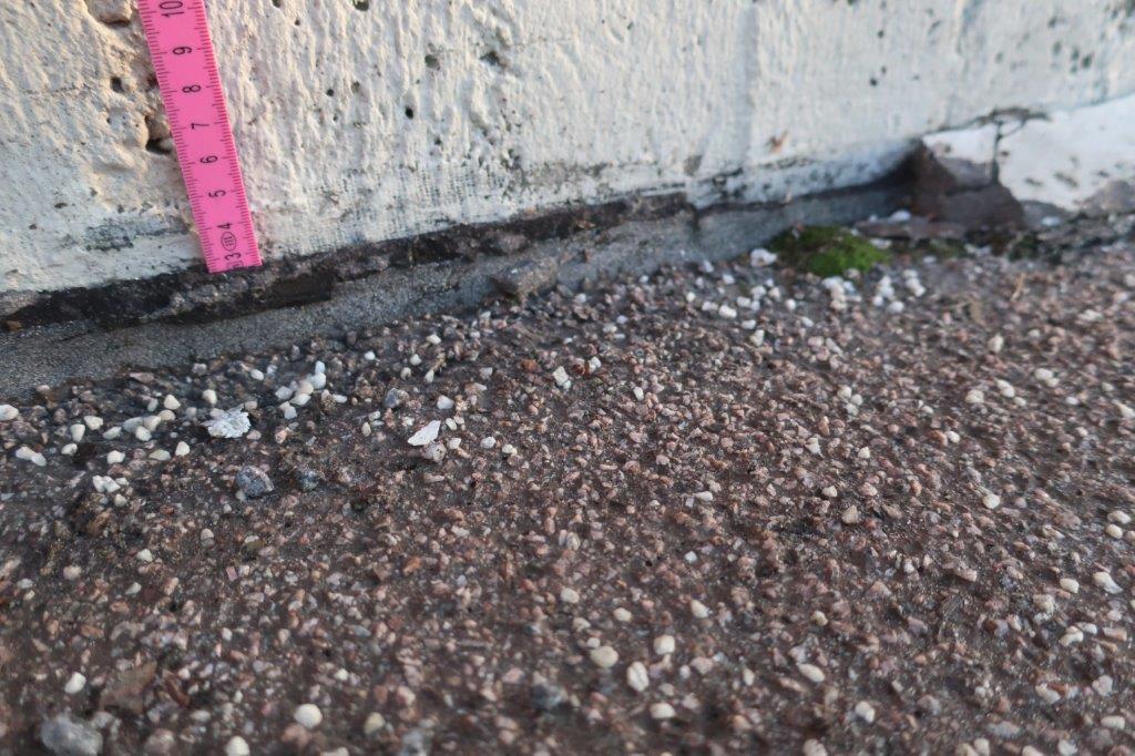Vägg stomlinje 4 Tumstock nedtryck ca 30 mm bakom matta Tätskiktsmatta Hålkäl Gjutasfalt rampens ovansida Bild 10. Tätskiktsuppvik som släppt utmed vägg och trasigt hålkäl.