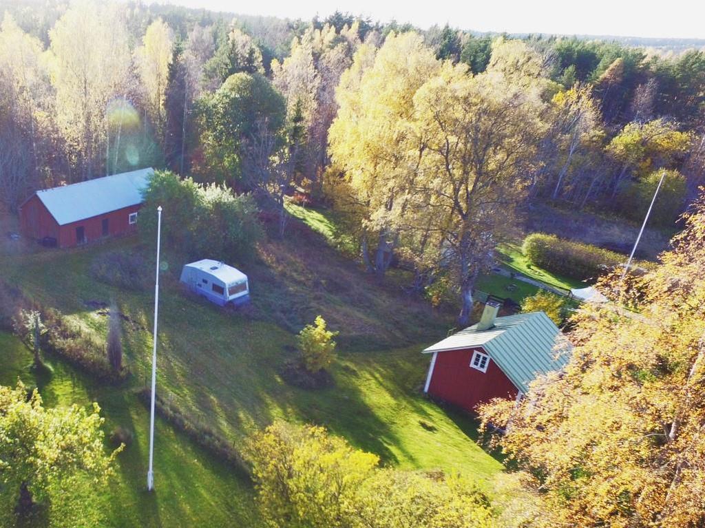 Torpet till höger, husvagnen som använts som gäststuga samt uthuset/ladugården uppe till vänster.