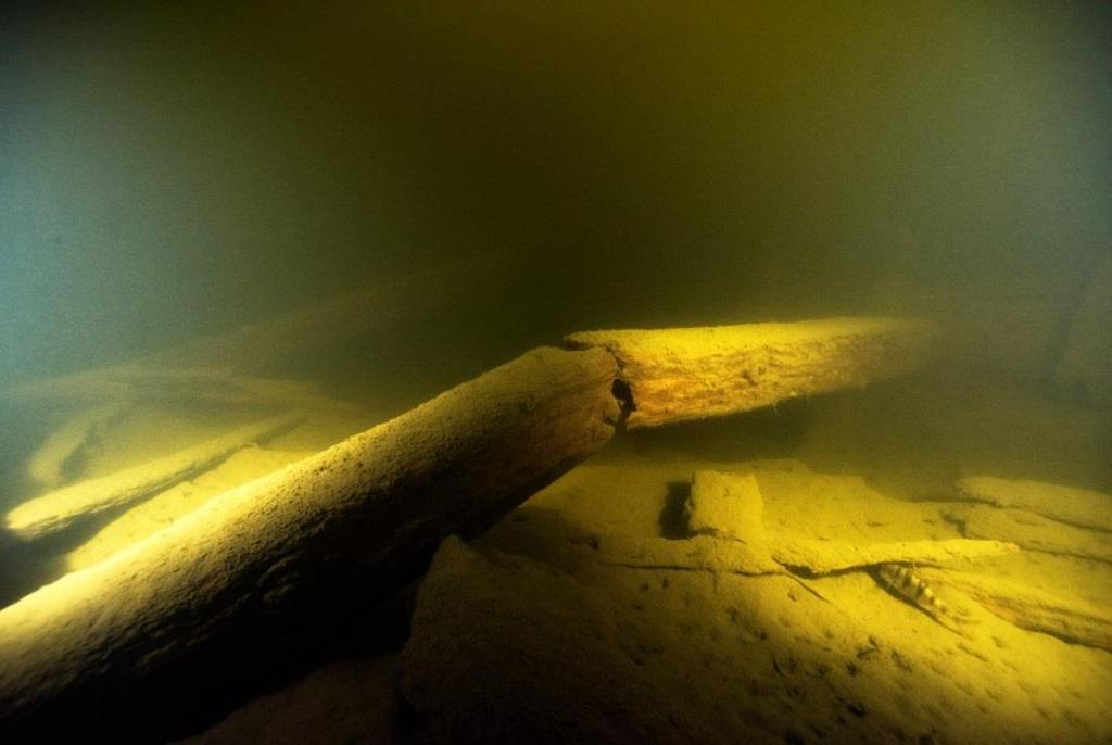 Figur 15. Bilden visar en av balkarna som är knäckt. I bakgrunden kan man skymta en hel balk samt styrbordssidan. Vraket har en svag slagsida mot babord. Foto: Jim Hansson, Statens maritima museer.