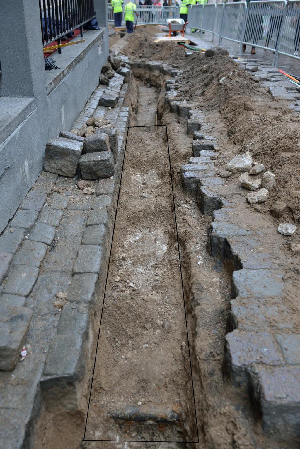 Stenläggning börjar cirka 19,5cm under nuvarande gatunivå och är cirka 25cm djup i två skift med kalkbruk. I den östra delen fanns även inslag av tegel.