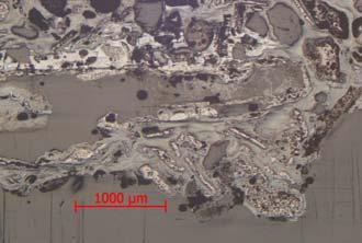 Visserligen är det avfall från smide, med den rikliga förekomsten av glödskal, men det är endast en sekundär bildning. Figur 10b. Från Lager 2 (BlM 27522). Foto från mikroskopet på polerat tvärsnitt.